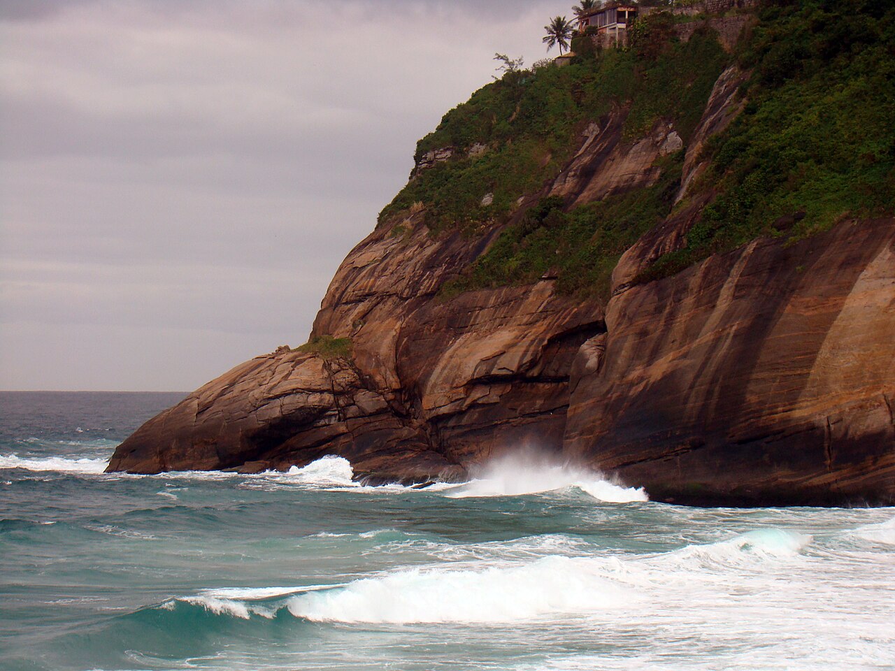 Atlantic surf reaching the cliffs at Praia da Joatinga
