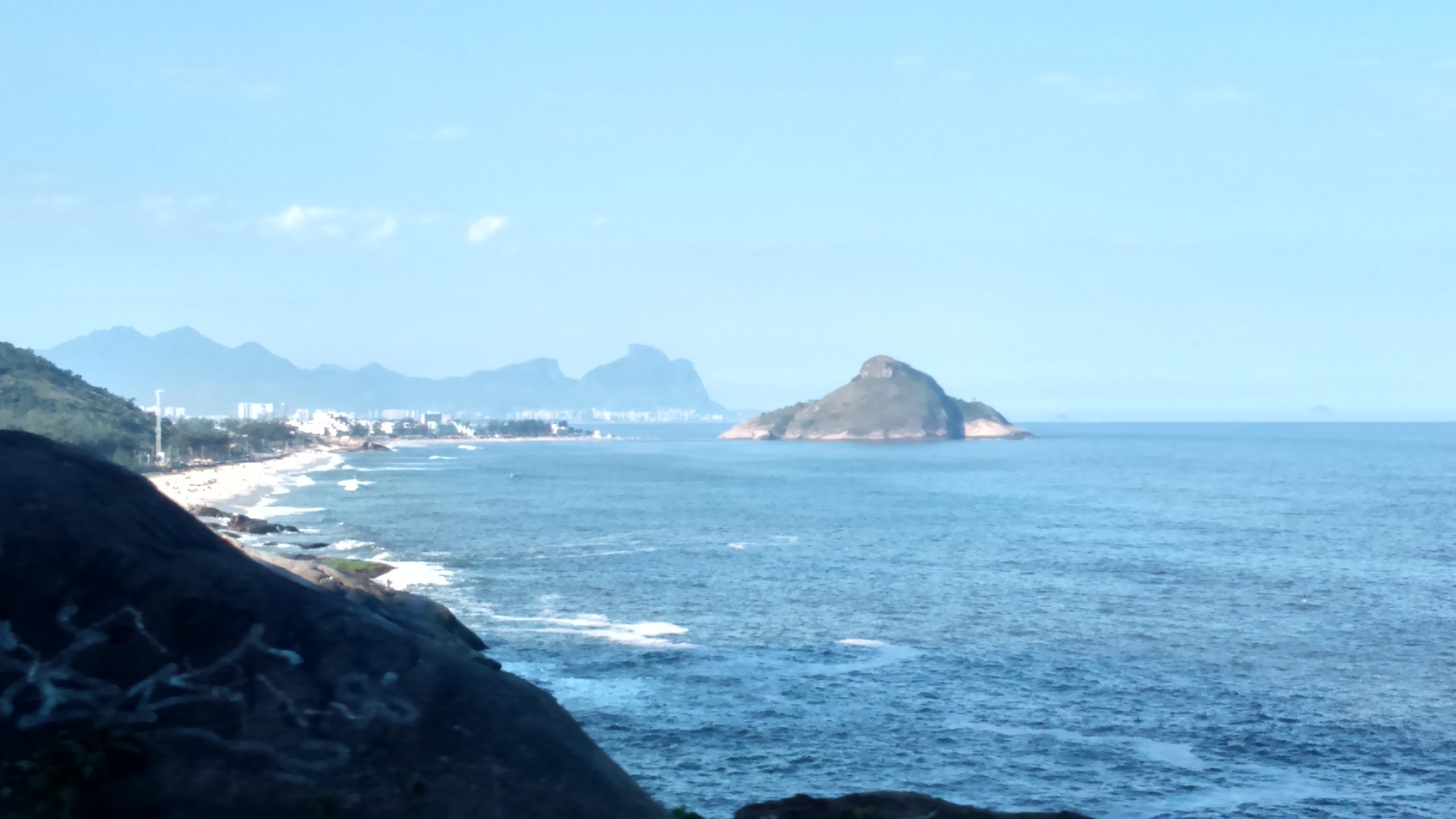 Praia da Macumba shoreline viewed from Mirante do Roncador, with Pedra do Pontal in the foreground and Rio’s western coast beyond