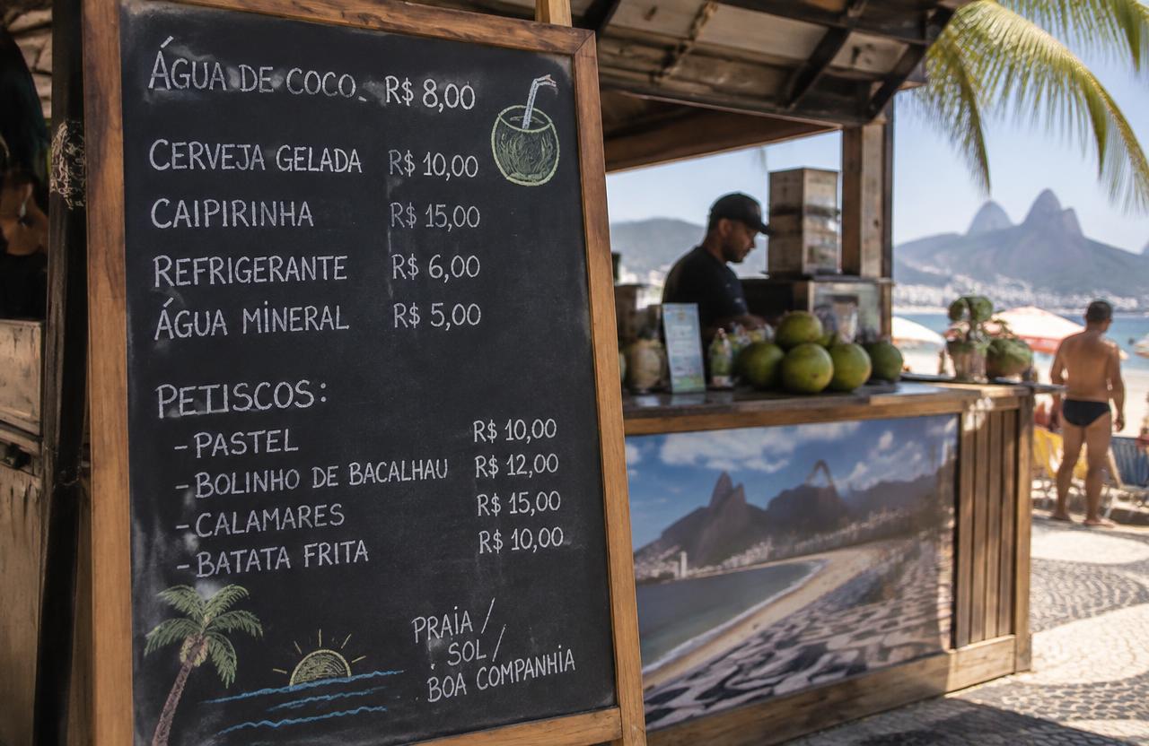 Portuguese-language menu board at a beach kiosk in Rio de Janeiro