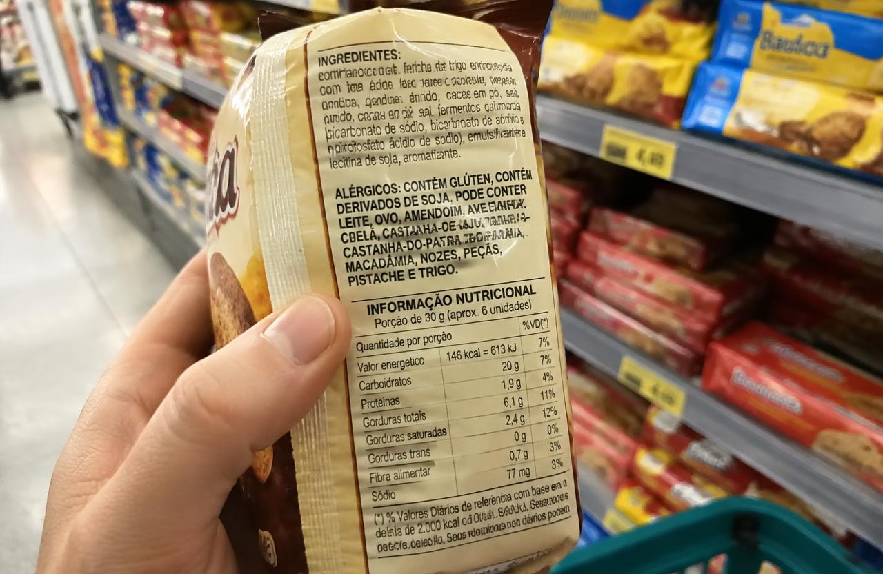Reading the ingredients label on a packaged product in a Rio de Janeiro supermarket
